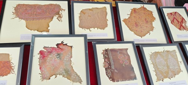 Framed pieces of Pashmina destroyed in the fire, a reminder of both beauty and tragedy, are on sale for whatever price customers are willing to offer. (Express Photo)