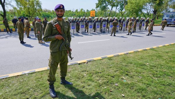 A police officer stands guard while others attend a briefing prior to their deployment to ensure security ahead of the United States and Iran possible negotiations in the Pakistani capital, Islamabad. (AP Photo)