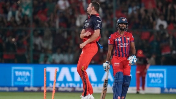 Lucknow Super Giants' Nicholas Pooran, right, reacts after getting bowled out by Royal Challengers Bengaluru's Josh Hazlewood during an Indian Premier League cricket match. (AP Photo)
