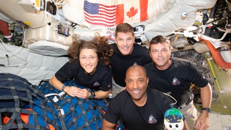 The crew of the Artemis II mission, clockwise from left: Mission Specialist Christina Koch, Mission Specialist and Canadian Space Agency astronaut Jeremy Hansen, Mission Commander Reid Wiseman and Pilot Victor Glover pose for a group photo with their zero gravity indicator ÒRiseÓ inside the Orion spacecraft on April 7, 2026. The crew members are scheduled to splash down off the coast of San Diego