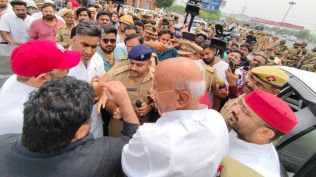 A Samajwadi Party delegation led by Mata Prasad Pandey, Leader of Opposition in the Uttar Pradesh Assembly, was stopped from meeting workers in Noida on Friday, after which they sat on the road near the DND Flyway in protest.
