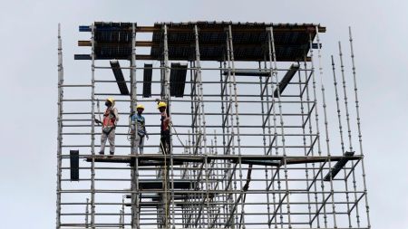 Migrant construction workers on a scaffold in Kerala, as large-scale return migration for elections in West Bengal and Assam disrupts key labour-dependent industries; Bihar
