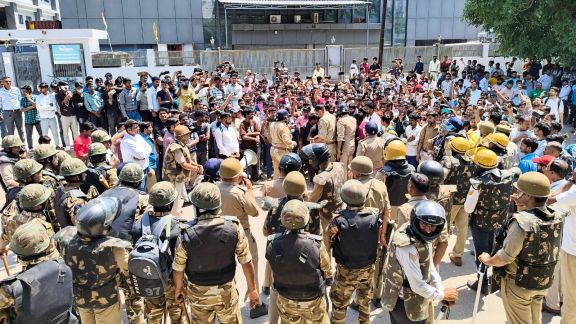 Factory workers scuffle with security personnel during a protest demanding a hike in wages, in Noida on Monday. (ANI Photo)