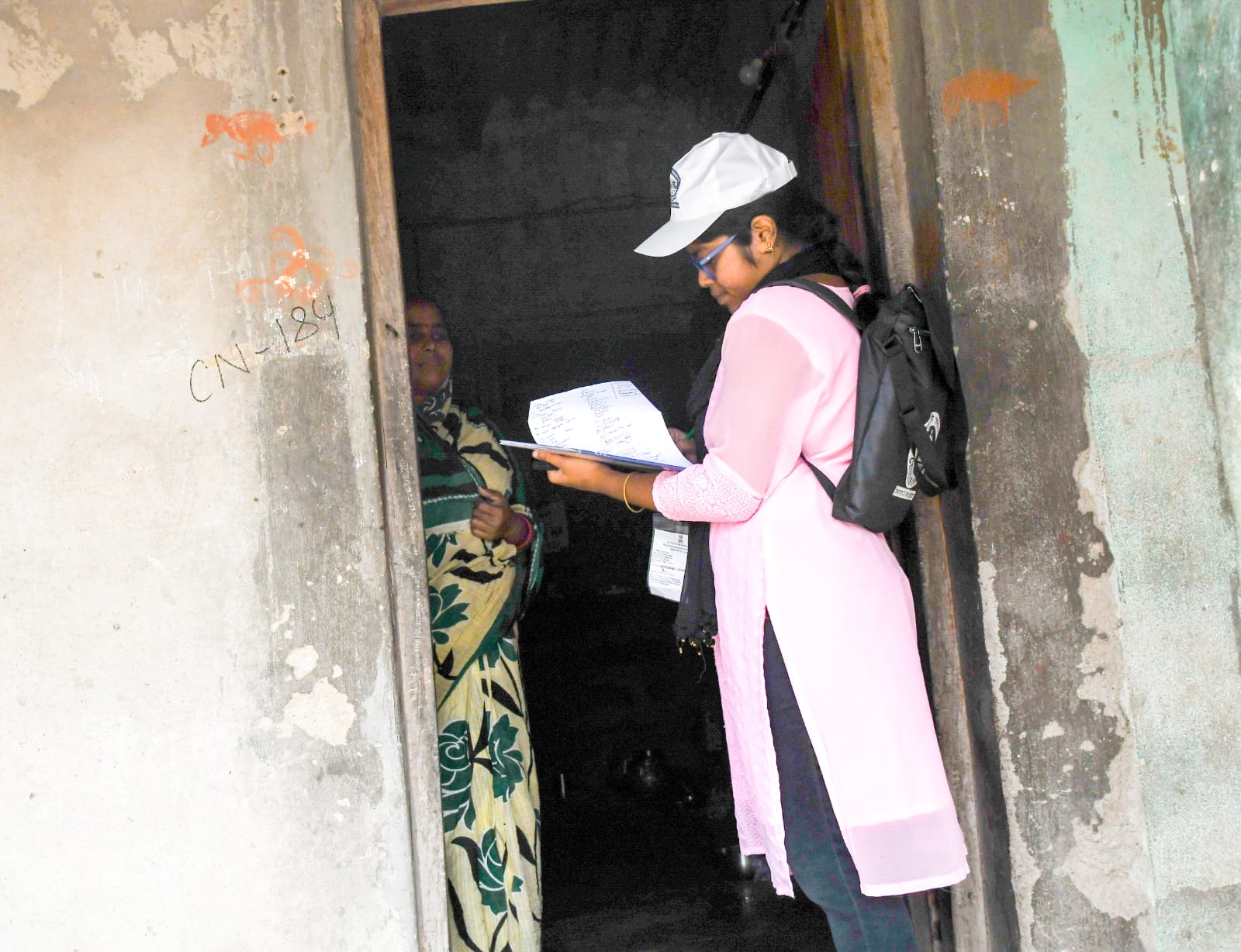 Sarmishta Sahoo going from door to door to map buildings and collect data on amenities using a mobile app. (Express photo: Sujit Bisoyi)