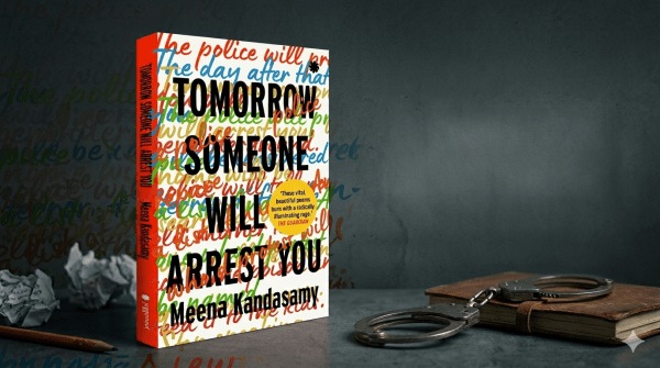 The book cover of Meena Kandasamy's poetry collection, Tomorrow Someone Will Arrest You sits on a desk, with a pair of handcuffs next to it. 