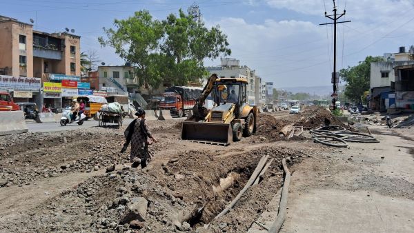 Commuters walk through Saswad Road, braving the dust from the ongoing construction. (Photo by Ira Kharshikar)