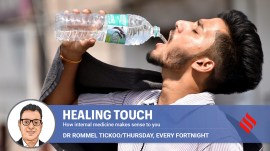 A commuter drinks water by the roadside shop to quench his thirst amid scorching heat.
