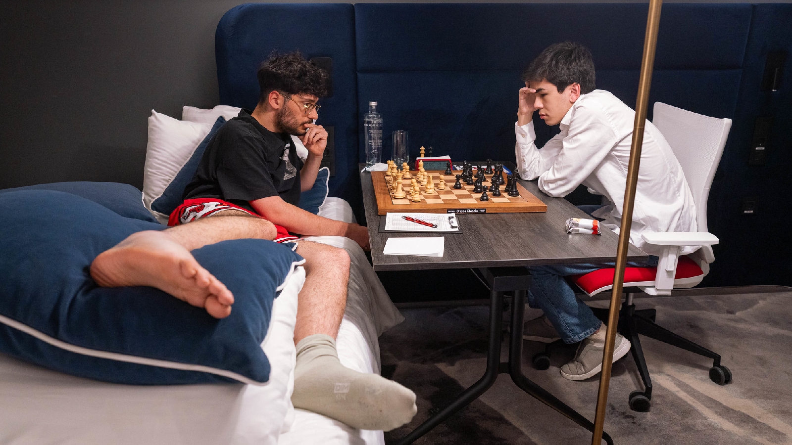Alireza Firouzja plays Javokhir Sindarov from his bed after injuring his ankle. (Photo: Lennart Ootes/Grand Chess Tour)