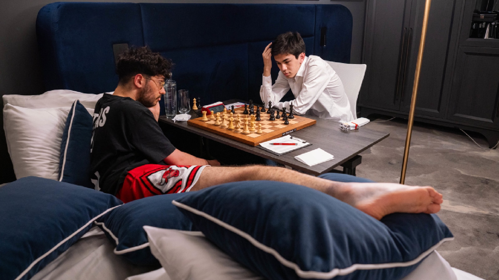 Alireza Firouzja plays Javokhir Sindarov from his bed after injuring his ankle. (Photo: Lennart Ootes/Grand Chess Tour)