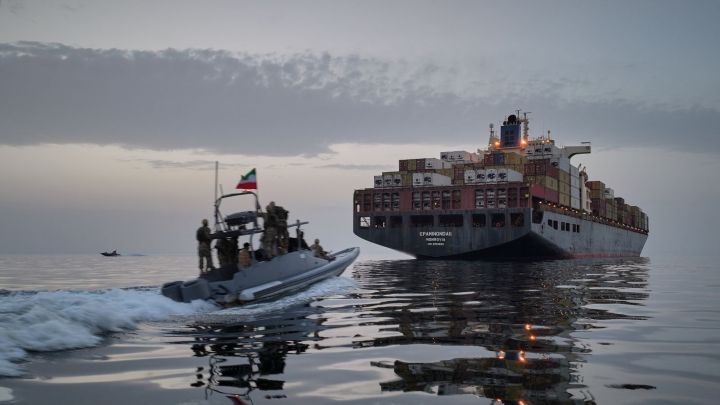 An IRGC speedboat approaches the cargo ship Epaminondas during what state media described as the seizure of one of two vessels accused of violations in the Strait of Hormuz. (AP Photo)