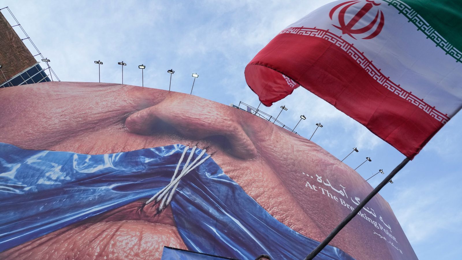 Billboard with graphics showing Strait of Hormuz and sewn lips of US President Donald Trump in a square in downtown Tehran. (AP Photo)