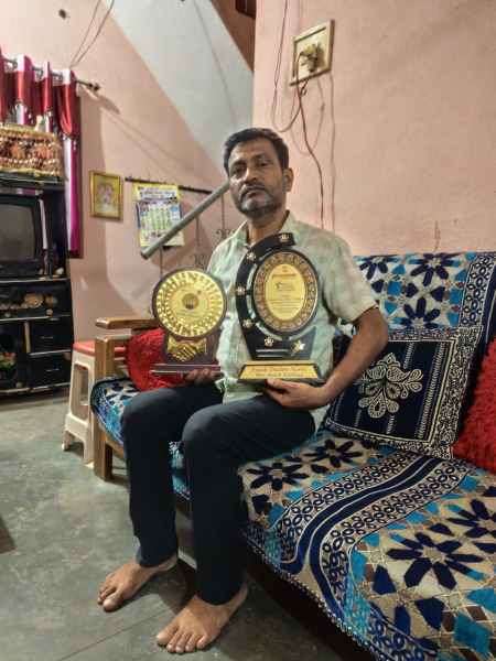 Local Congress leader Sammelan Kashyap holds up mementos from cement companies won by his son Ayush for his cement business. (Express photo: Jayprakash S Naidu)