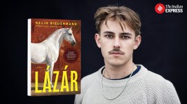 A photograph of Nelio Biedermann, the 22-year-old Swiss-Hungarian author of Lazar, alongside his book which features a white horse on a brown background and the title of the book. Biedermann is blond and wearing a cream sweater.