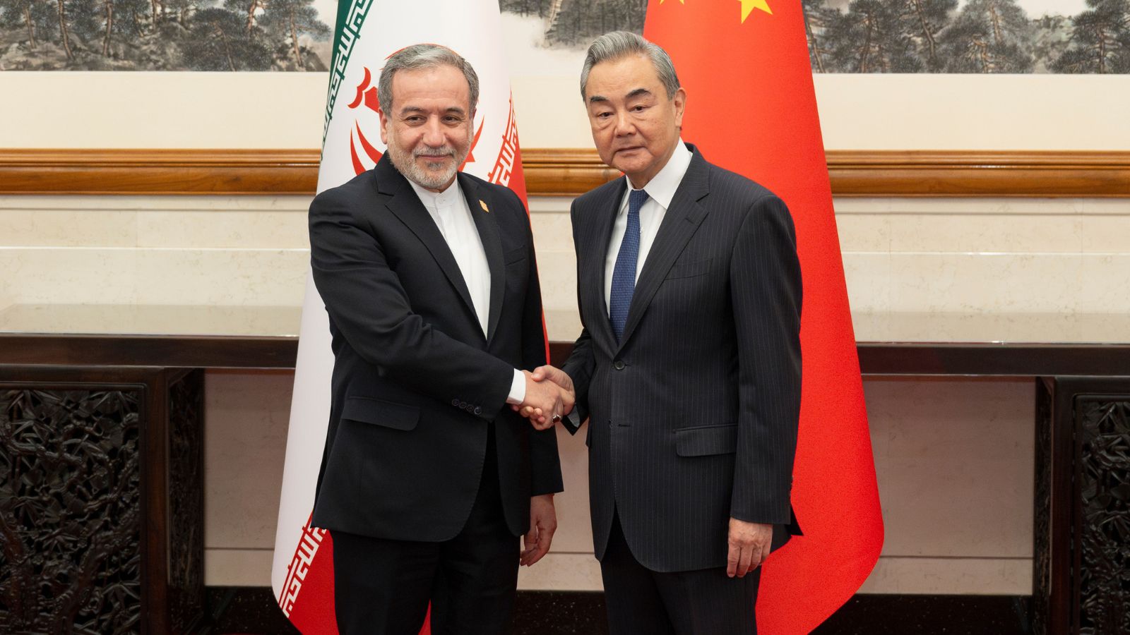 In this photo released by Xinhua News Agency, Iranian Foreign Minister Abbas Araghchi, left, is greeted by his Chinese counterpart Wang Yi prior to their bilateral meeting in Beijing, Wednesday, May 6, 2026. (Cai Yang/Xinhua via AP)