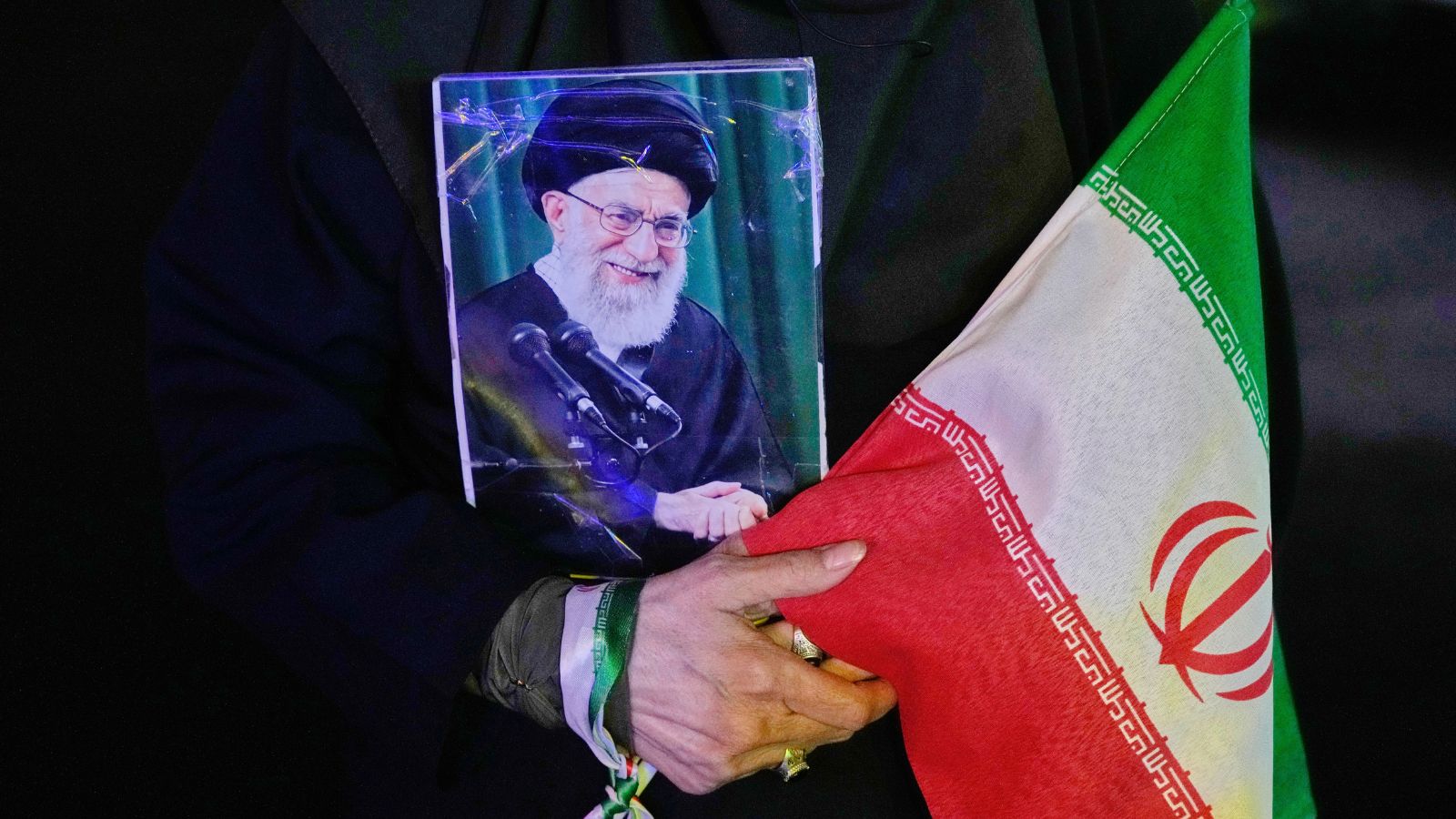 A demonstrator holds a poster of the slain Iranian Supreme Leader Ayatollah Ali Khamenei (Photo/AP)