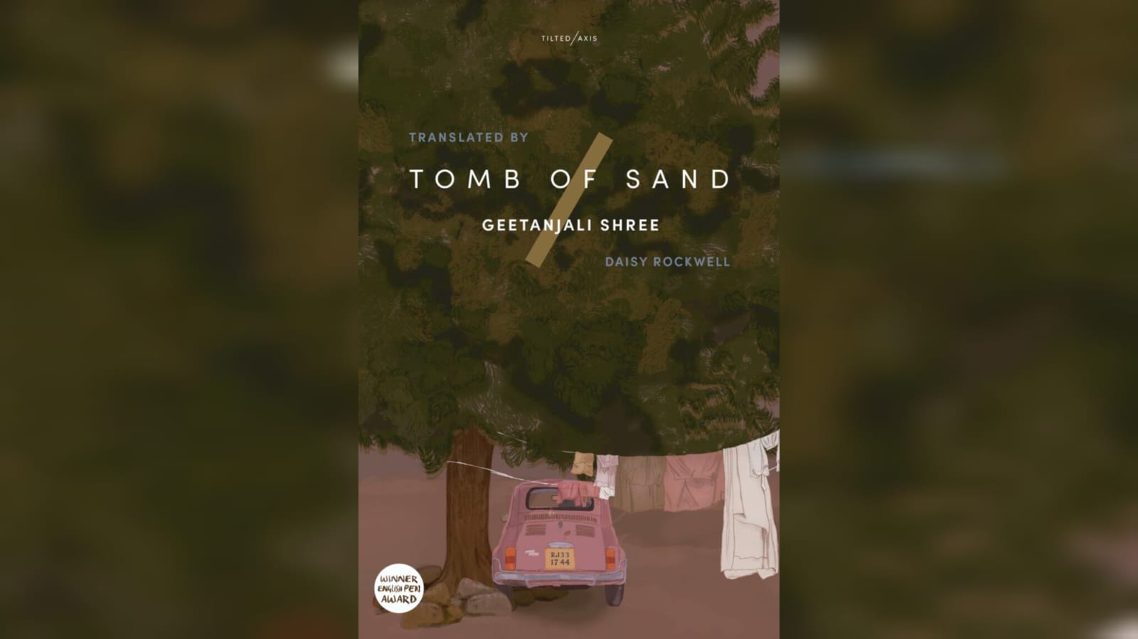 The book Ret Samadhi aka Tomb of sand written by Geetanjali shree.The bacground has a car parked on the side of a big tree and clothes are hanging by the side. 