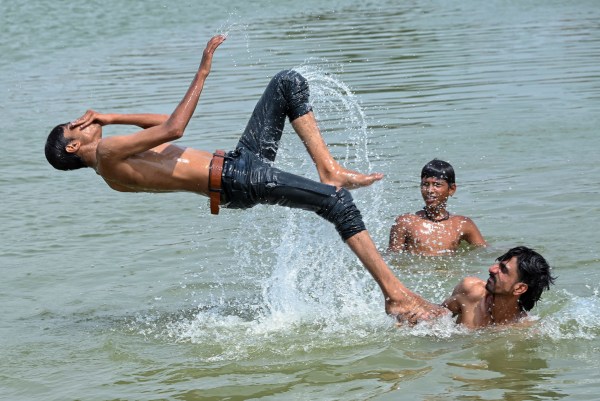 People enjoy a refreshing dip in a pond to escape the scorching sun and heat