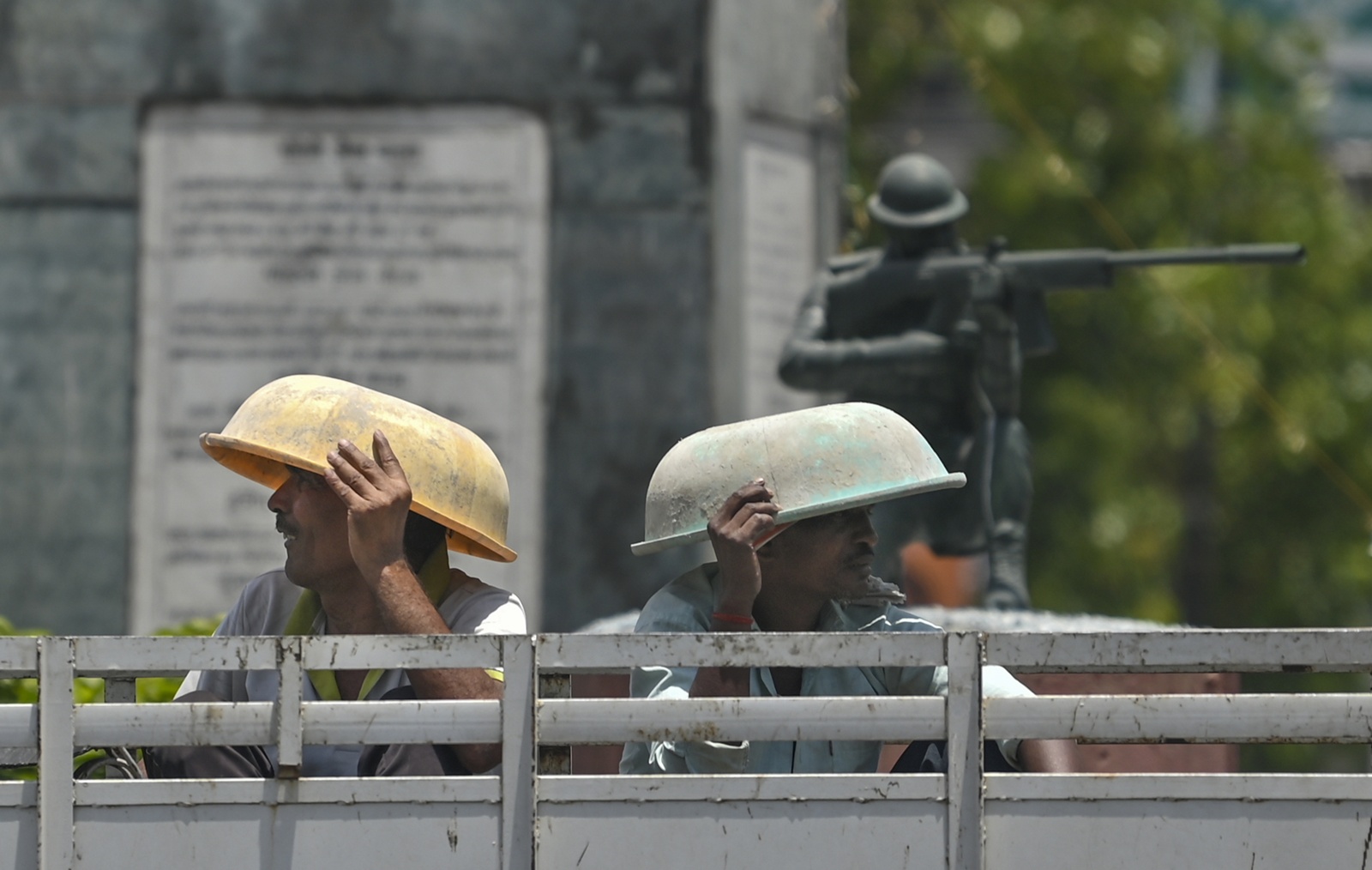 Workers cover themselves from the scorching heat