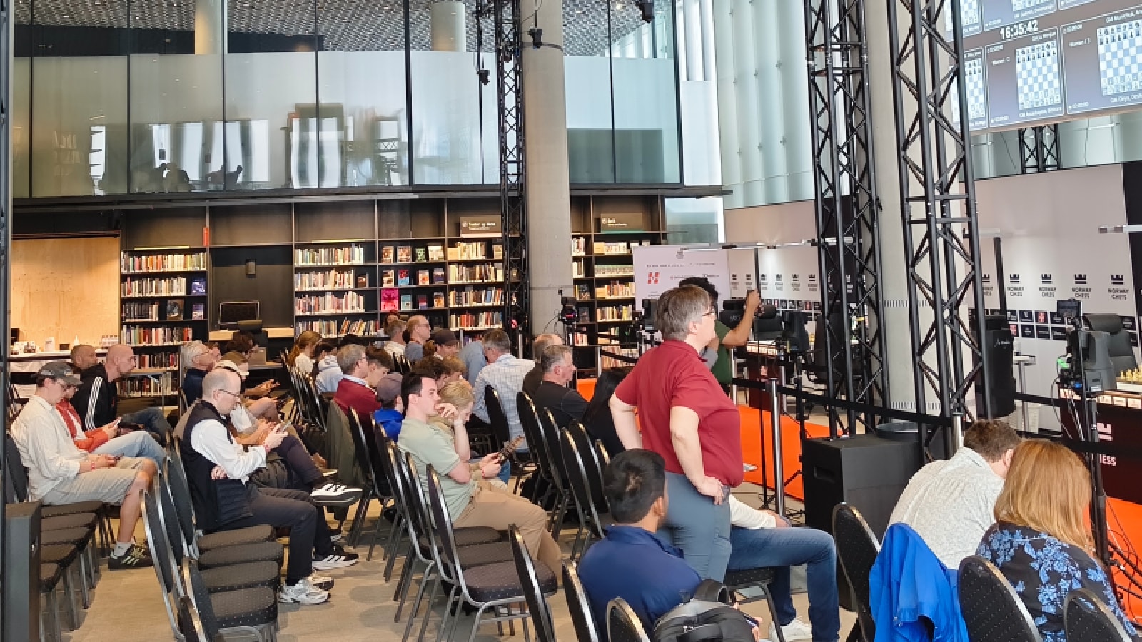 Seats at the Deichman Bjørvika in Oslo started to fill up half an hour before the first moves would be made. Most fans opted to sit in front of the Gukesh vs Magnus Carlsen board. (Express Photo by Amit Kamath)