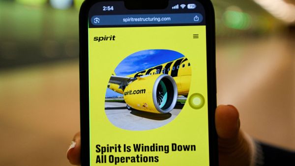 A mobile phone displays a Spirit Airlines operational update website. (REUTERS)