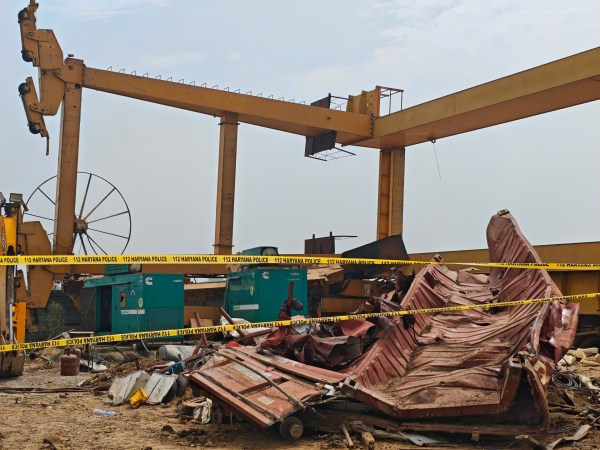 At the accident site on Friday, work was halted and a mangled red tin container lay where the crane fell. (Express Photo)