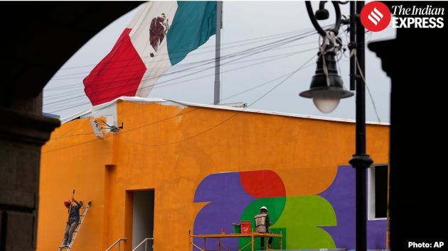 Workers paint a building in FIFA World Cup-themed colors in downtown Mexico