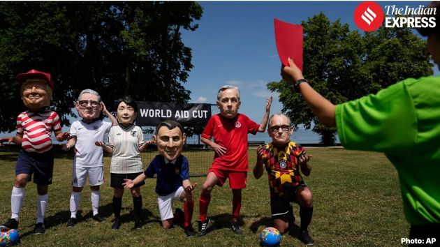 Oxfam's satirical 'big heads' of the G7 leaders pose dressed as soccer players at the soccer World Cup as a referee shows them a red card