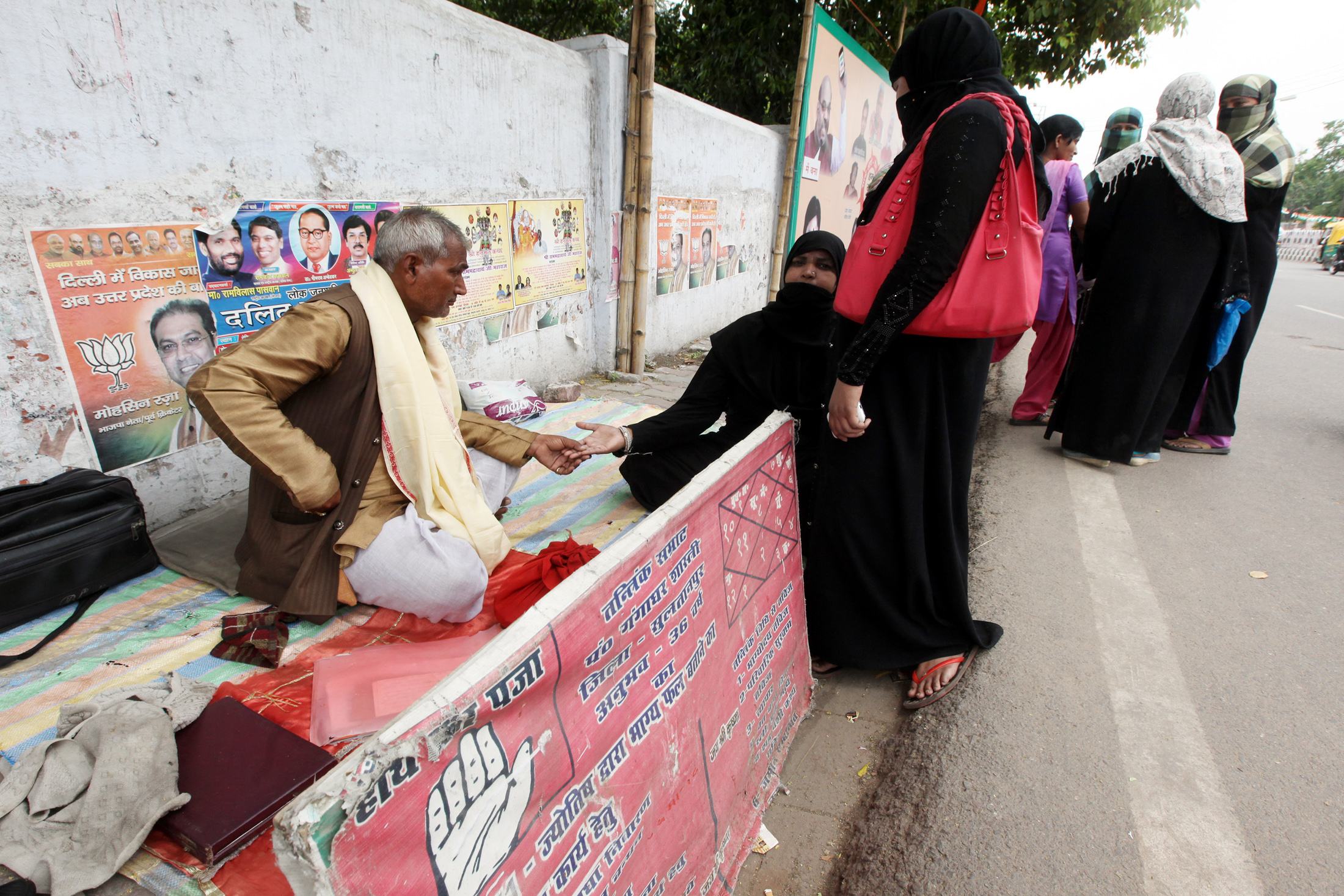 Women at a roadside palmist in front of state BJP office in Lucknow (Express Photo by Vishal Srivastav)