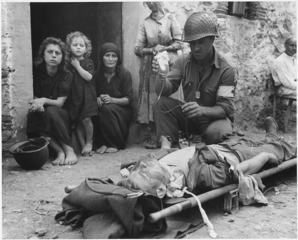 Wounded soldier being given blood plasma in Sicily, 1943 (Wikipedia)