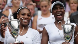 Serena Williams, left, and Venus Williams of the U.S hold their trophies after winning the women's doubles final against Yaroslava Shvedova of Kazahkstan and Timea Babos of Hungary on day thirteen of the Wimbledon Tennis Championships in London, July 9, 2016. (AP Photo/Tim Ireland, File)