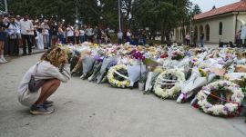 People gather beside flowers and wreaths at a memorial for the victims of the Bondi Beach terror attack in Sydney. (Source: AP Photo)