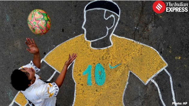A child plays with a soccer ball on a street decorated in Brasilia, Brazil