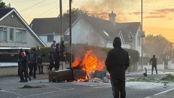 A fire burns in bins as anti-immigrant protesters clash with police at Antrim road, following a knife attack on June 8, which left a man seriously injured and prompted police to declare a critical incident, in Belfast, Northern Ireland, June 10, 2026. Picture taken with a phone. (Image: REUTERS)