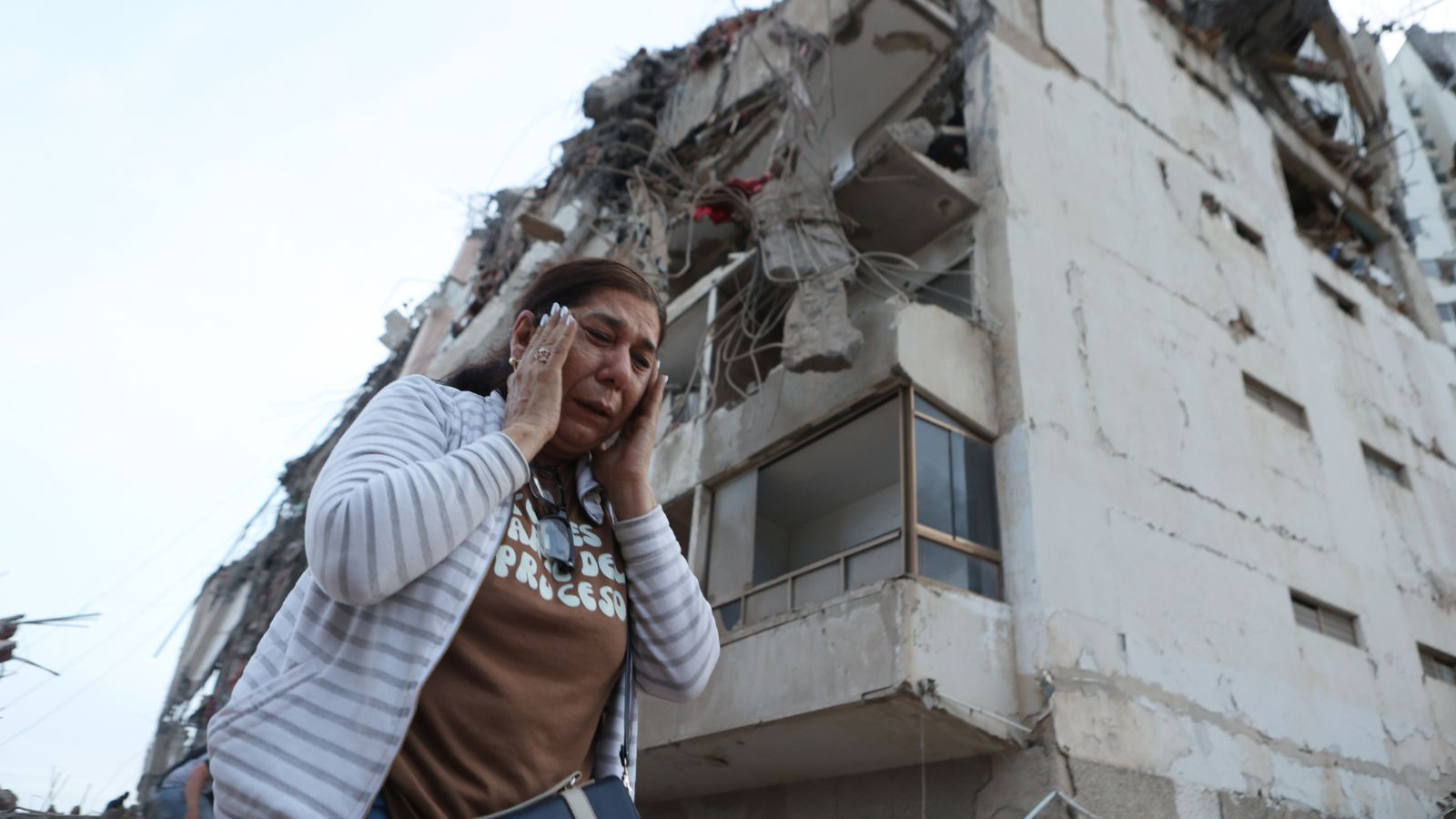 A woman walks past a building damaged during an earthquake in La Guaira, Venezuela. (Photo: AP)