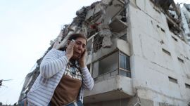 A woman walks past a building damaged during an earthquake in La Guaira, Venezuela. (Photo: AP)