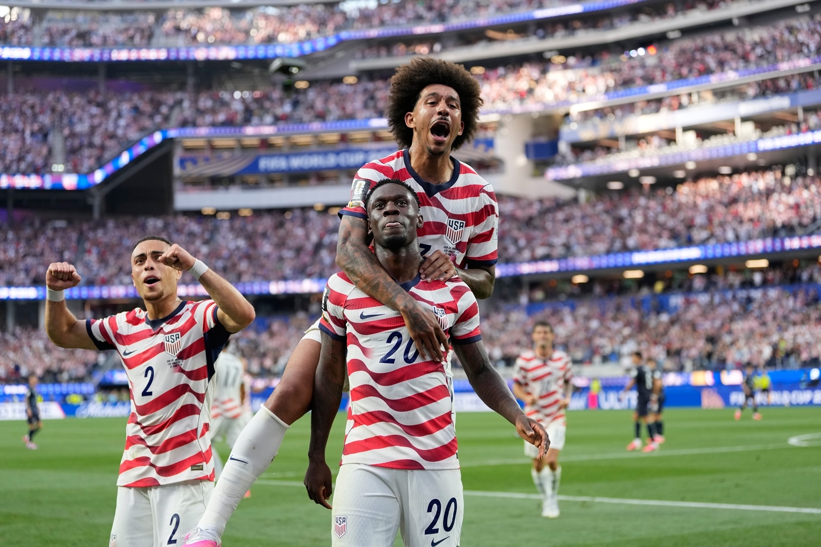 Folarin Balogun celebrates scoring his side's third goal against Paraguay with teamates during the World Cup Group D match. (AP Photo)