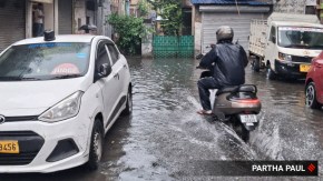Pedestrians and commuters wade through a waterlogged street amid heavy rainfall in North Kolkata. (Express Photo by Partha Paul)