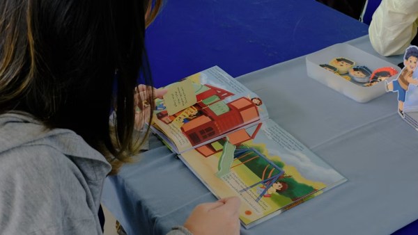 A girl reads a pop-up book. (Source: Unsplash) 