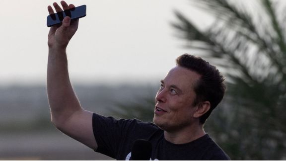 Elon Musk raises his phone towards the sky at the SpaceX Starbase, in Brownsville, Texas, US. (REUTERS)