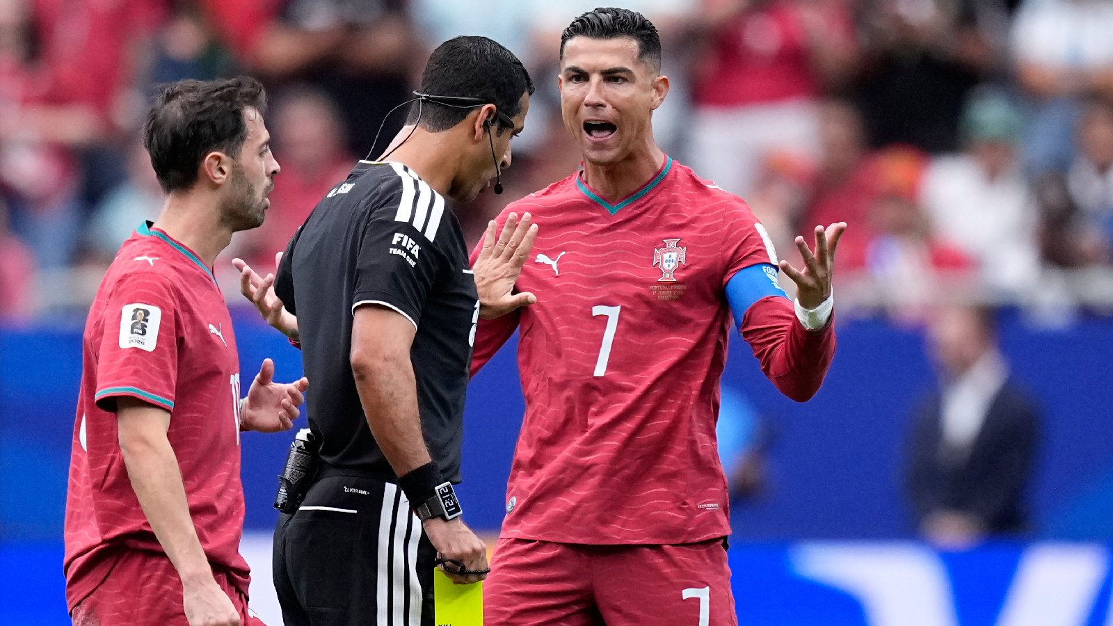 Portugal's Cristiano Ronaldo argues with referee Abdulrahman Al-Jassim, of Qatar, after he showed a yellow card to Bernardo Silva, left, during the World Cup Group K soccer match between Portugal and Congo in Houston, Wednesday, June 17, 2026. (AP Photo/Ashley Landis)