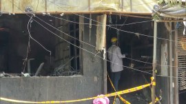 Forensic teams at the site where a catastrophic fire broke out, reportedly claiming 21 lives