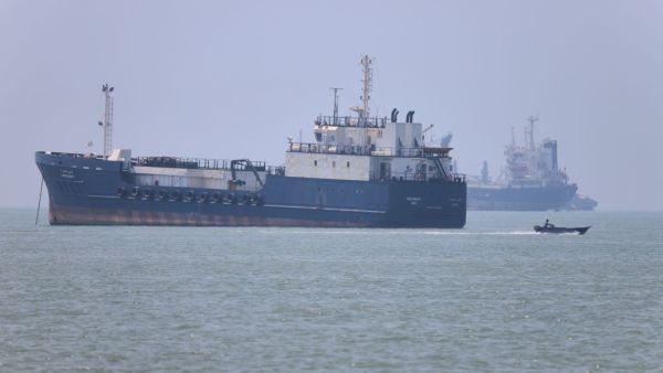 A small motorboat passes anchored vessels in the Strait of Hormuz off Bandar Abbas, Iran, Wednesday, June 17, 2026.(Amirhosein Khorgooi/ISNA via AP)