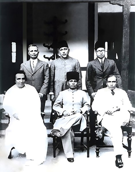Swearing-in of Coalition Ministry in Assam, British India, with Muslim League and Congress parties, with Muslim, Hindu and Christian Ministers and Sir Saadullah as Premier. Rohini Kumar Choudhury seated left. (Wikimedia Commons)