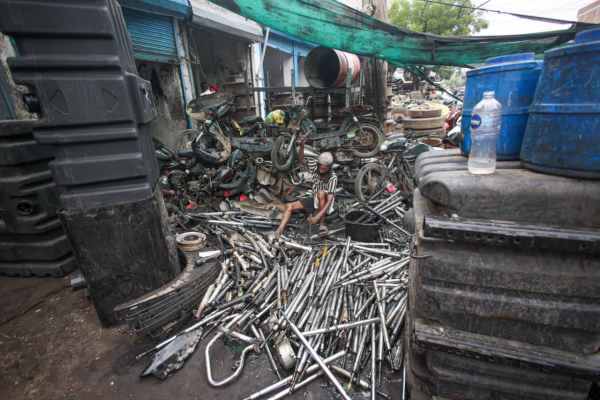 A worker dismantles two wheeler parts at  Mayapuri. (Express Photo by Praveen Khanna)