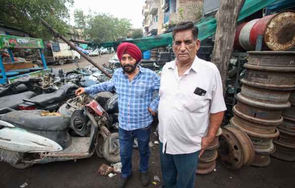 Vijay Dhingra with his apprentice in front of their automobile scraps outlet at Mayapuri. (Express Photo by Praveen Khanna)