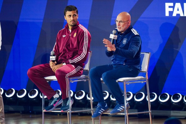 Spain's Rodri listens as head coach Luis de la Fuente speaks during a news conference ahead of the World Cup final against Argentina in New York. (AP Photo/Stephanie Scarbrough)