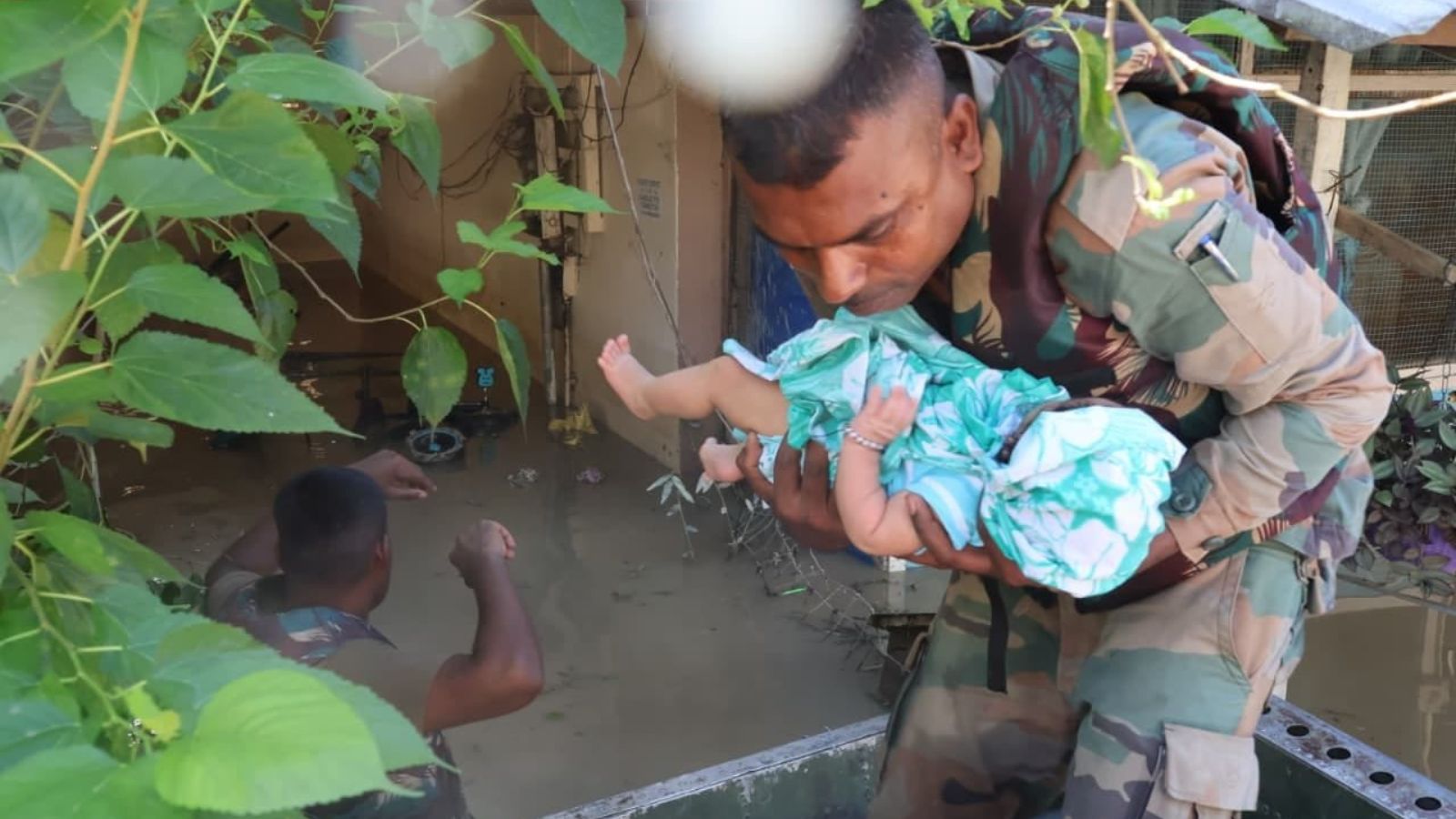 Indian Army personnel rescue a baby from a flood-hit area.