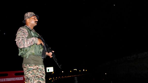 An armed CRPF official stands guard on the Jammu–Srinagar Highway (NH-44) before the arrival of the first batch of Amarnath Yatra pilgrims, in Udhampur on Thursday. (ANI Photo)