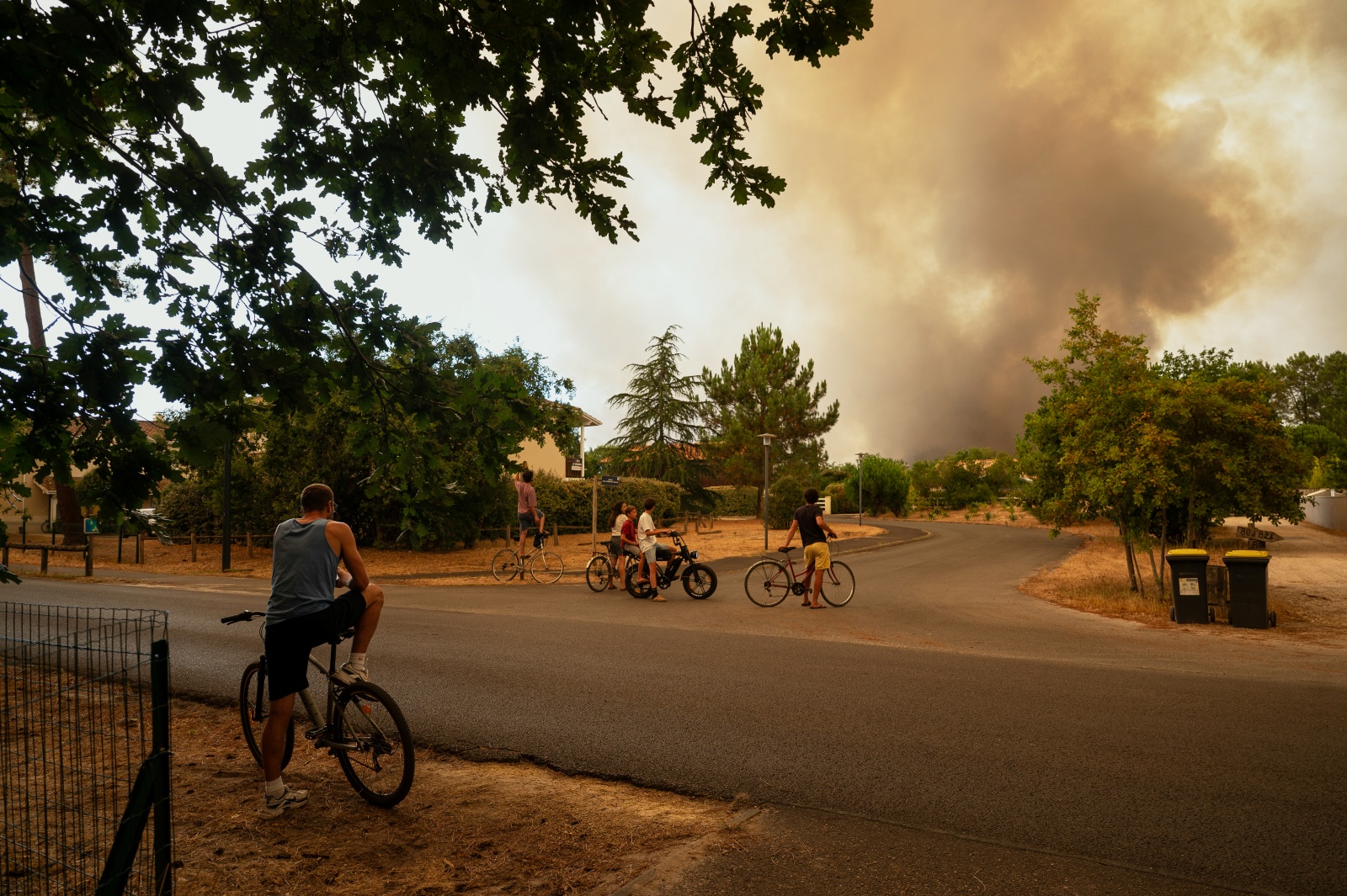 People watch massive plumes of smoke caused by wildfires in Le Porge, western France