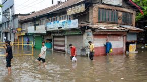 People wade through a knee-deep waterlogged road after heavy rain, in Srinagar, Monday, July 20, 2026. (PTI Photo)